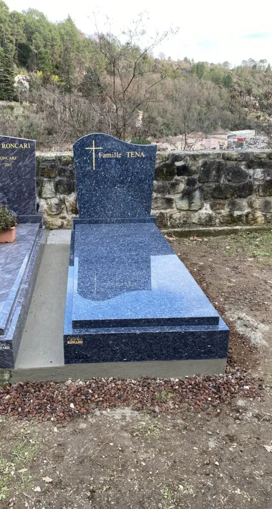 Tombe moderne en granit bleu nacré avec stèle personnalisée au cimetière.