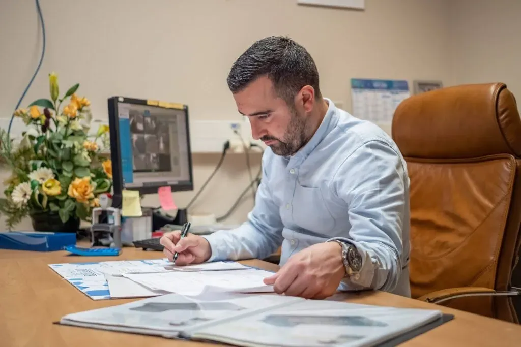 Conseiller funéraire travaillant à son bureau sur un dossier d'obsèques.
