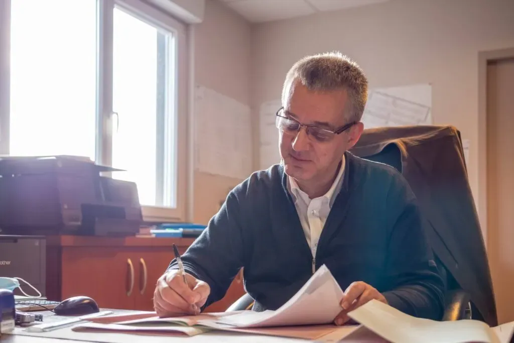 Conseiller funéraire à son bureau, concentré sur la préparation de dossiers administratifs.